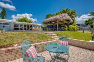 a patio with a table and chairs and a building at TIPSY TIKI - Pool, Canal, Outdoor Bar, King Bed in Cape Coral