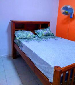 - une chambre avec un lit en bois et des draps bleus dans l'établissement Baobab immobilier Thiès, à Thiès