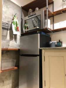 a microwave sitting on top of a refrigerator in a kitchen at Loft Privativo - Centro BC - com Garagem in Balneário Camboriú