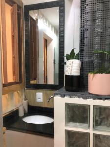 a bathroom with a sink and a mirror at Loft Privativo - Centro BC - com Garagem in Balneário Camboriú