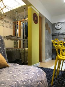 a room with yellow chairs and a clock on the wall at Loft Privativo - Centro BC - com Garagem in Balneário Camboriú +9 photos