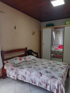 Un dormitorio con una cama con una colcha floral. en Quartos residencial, en Belém