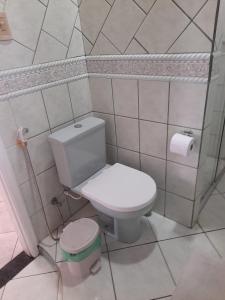 Un baño con un inodoro blanco en una habitación. en Quartos residencial, en Belém