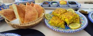 una mesa cubierta con platos de comida y pan en Grandpa's Farm ضيعة جدّي, en Nebeur