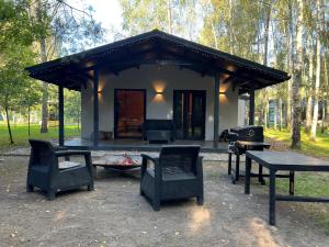 LaskowiceAckermannia的一间带椅子、桌子和烤架的小屋