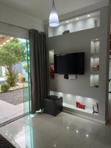 Una sala de estar con un televisor de pantalla plana en la pared. en Porto Casa Spa, en Penha