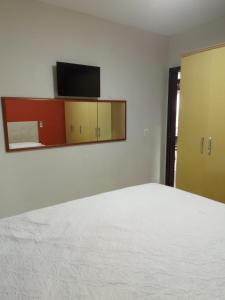 Un dormitorio con una cama y un televisor en una pared. en Porto Casa Spa, en Penha