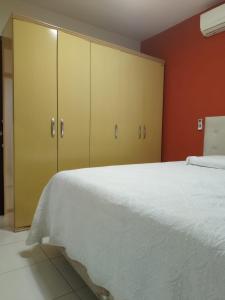 1 dormitorio con cama blanca y armarios amarillos en Porto Casa Spa, en Penha