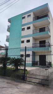 un edificio con una valla delante en Apartamento Prainha perto de tudo pe na areia - 3 andar escada, en Caraguatatuba