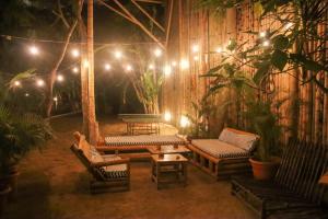 a patio with chairs and a table and lights at Hidden Hostel in Montañita