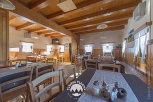 a dining room with tables and chairs and wooden ceilings at Brunarica in Bohinj