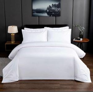 a white bed with white sheets and pillows at E-Luxe Suites Hotel in Abuja