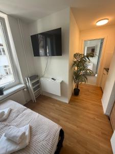 a bedroom with a bed and a tv on the wall at M&S Apartments - St Gallen City - 5 min Bahnhof in St. Gallen +12 photos