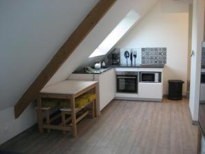 an attic kitchen with a table and a stove at Appartement L'Eden de la Guyonnière 2 chambres in Ruaudin