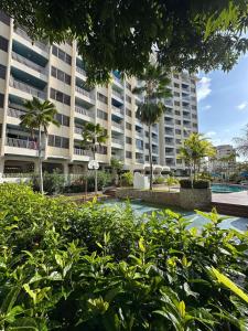 ein großes Gebäude mit Palmen davor in der Unterkunft Apartamento de Ensueño en Belair Frente al Mar in Caraballeda