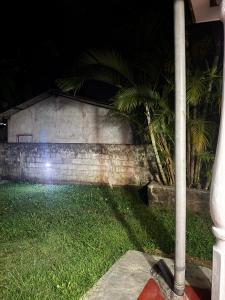a house with a pole in the grass at night at Seliya Villa Retreat in Balapitiya