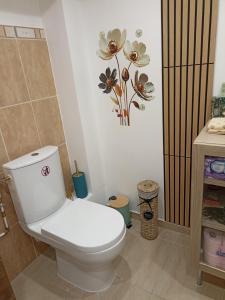 a bathroom with a toilet with a flower picture on the wall at L'océane in Saint-Maurice-de-Beynost +29 photos
