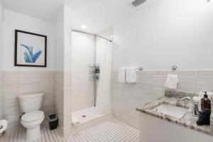 タンパにあるCasa Ybor Apartments on 7th Aveのトイレとシャワー付きの白いバスルーム +17枚の写真