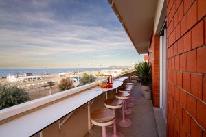 a balcony with bar stools and a view of the beach at Casa Idillio in Misano Adriatico