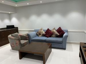 a living room with a blue couch and a coffee table at شقق مفروشه رقميه في العزيزيه in Riyadh