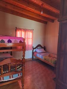 Un dormitorio con dos camas y una ventana. en Casa El Arenal, en Cachí