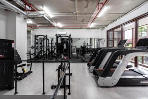 a gym with treadmills and machines in a room at Lè Métropole Saigon in Ho Chi Minh City