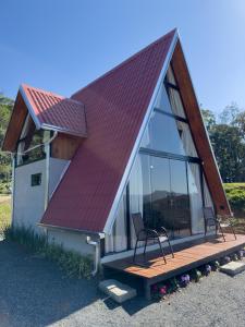 a house with a red roof and two chairs on a deck at Morro dos Chalés in Pomerode
