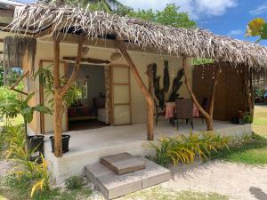 a small house with a thatch roof and a patio at Teumuhonu Tikehau in Tikehau