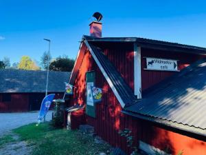 a red building with a chimney and a sign on it at 4 person holiday home in HALLABRO-By Traum in Hallabro +22 photos