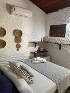 ein weißes Schlafzimmer mit einem Bett mit Kissen darauf in der Unterkunft Bougainville Icaraí de Amontada in Amontada + 17 Fotos