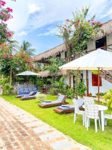 a patio with chairs and tables and umbrellas at Bougainville Icaraí de Amontada in Amontada