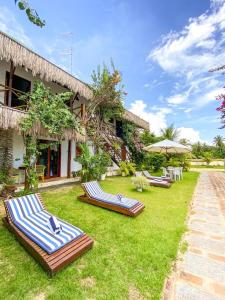 a group of lounge chairs on the grass in front of a building at Bougainville Icaraí de Amontada in Amontada +17 photos