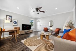 アーリントンにあるWalk to AT&T Stadium - Modern 2BR With Backyardのソファと天井ファンのあるリビングルーム