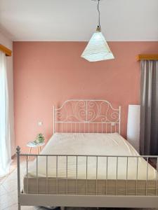 una camera da letto con un letto e una parete rosa di Casa Verde Trikala a Tríkala