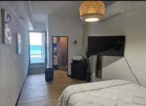 a bedroom with a bed and a flat screen tv at Villa Molina Del Mar in Arecibo