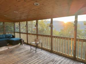 a screened in porch with a couch and a table at Cozy Forest Escape with Porch and AC in Lost City