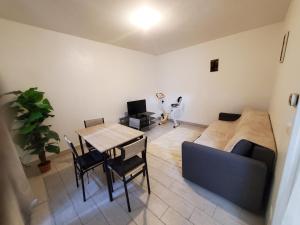 a living room with a table and a couch at Le Refuge Nature à 20 min de Paris et d'Orly via RER Juvisy in Draveil