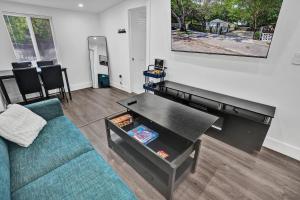 マイアミにあるMiami Heart Retreat, Stylish & Central With Gamesの青いソファとテーブルのあるリビングルーム