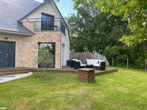 a patio with couches and a table in a yard at L'Eden de la Guyonnière in Ruaudin