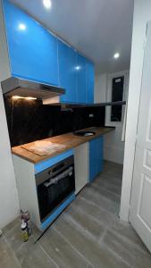cocina con armarios azules y fogones en Maison, au calme, en Sarcelles