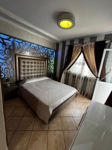 Un dormitorio con una cama y una pared azul. en El alaoui rents, en Tetuán