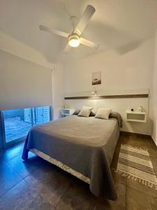 a bedroom with a bed with a ceiling fan at Departamento 2 ambientes Complejo Amarras Pinamar con pileta y servicios in Pinamar