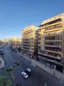 a street with cars parked in front of tall buildings at Cairo Nomads Hostel in Cairo