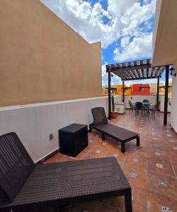 a patio with benches and tables on a building at Casa Fray in San Miguel de Allende