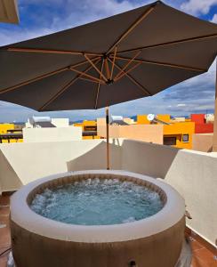 een hot tub met een parasol op een balkon bij Casa Fray in San Miguel de Allende