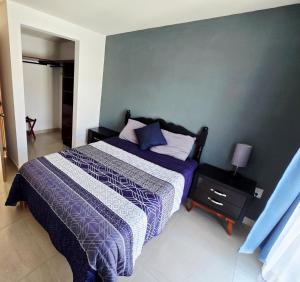 een slaapkamer met een bed met een paars en wit dekbed bij Casa Fray in San Miguel de Allende