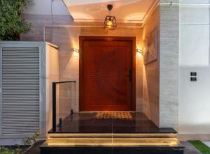 a large wooden door in a building with a light at Luxury Family Villa with Private Pool in Sheikh Zayed Khan in 6th Of October