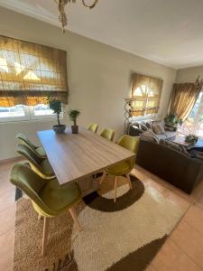 a dining room with a wooden table and green chairs at Casa Verde Trikala in Tríkala