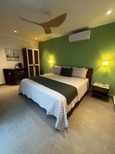 a bedroom with a large bed with a green wall at Central Hotel Boutique in Las Galeras +14 photos
