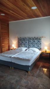 Una cama grande en una habitación con dos lámparas. en Seva, en Obligado
